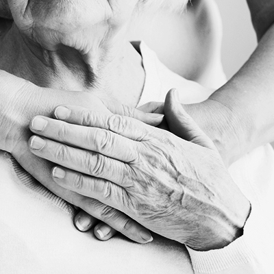 A caregiver holding hands with an elderly resident in a senior living community